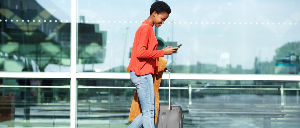 Woman using smart phone to navigate through airport using Atrius wayfinder